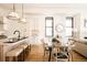 Spacious living room with glass dining table, island seating, hardwood floors and modern lighting fixtures at 2751 Curtis St, Denver, CO 80205