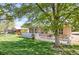 Beautifully landscaped backyard featuring a white picket fence and mature trees at 8951 Greenwich St, Highlands Ranch, CO 80130
