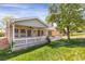 Charming backyard with a covered patio, white fence, and lush green lawn at 8951 Greenwich St, Highlands Ranch, CO 80130
