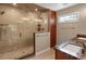 Bathroom with a glass-enclosed shower, granite countertops, and wood cabinets at 8951 Greenwich St, Highlands Ranch, CO 80130