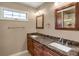 Bathroom featuring dual sinks with marble countertops and wood cabinets at 8951 Greenwich St, Highlands Ranch, CO 80130