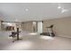 Large carpeted home gym area connected to a kitchenette with bar seating at 8951 Greenwich St, Highlands Ranch, CO 80130