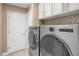 Laundry room equipped with modern washer and dryer units, and storage cabinets at 8951 Greenwich St, Highlands Ranch, CO 80130