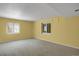 Carpeted room with bright yellow walls, with large windows, that bring in natural light at 8951 Greenwich St, Highlands Ranch, CO 80130