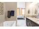 Open bathroom featuring tub with jets, tiled wall accents and doorway view to the bedroom at 2397 E Iliff Ave, Denver, CO 80210