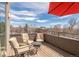 This deck features chairs and a table, and is shaded by a red umbrella at 2397 E Iliff Ave, Denver, CO 80210