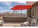 This deck features chairs and a table that overlook a distant landscape at 2397 E Iliff Ave, Denver, CO 80210