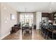 Open concept dining room with hardwood floors features modern lighting and large windows for natural light at 2397 E Iliff Ave, Denver, CO 80210