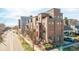 Charming townhouse featuring a well-manicured lawn, beautiful landscaping, and a red umbrella on the balcony at 2397 E Iliff Ave, Denver, CO 80210