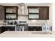 Modern kitchen featuring stainless steel appliances, dark cabinetry, and stylish backsplash at 2397 E Iliff Ave, Denver, CO 80210