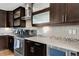 Kitchen with stainless steel appliances, stone countertop, and dark wood cabinets at 2397 E Iliff Ave, Denver, CO 80210