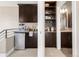 Modern kitchenette featuring dark wood cabinets, mini fridge, and a passthrough to the bathroom at 2397 E Iliff Ave, Denver, CO 80210