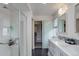 Modern bathroom featuring dual sinks, a glass shower, and an adjacent closet space at 10906 Touchstone Loop, Parker, CO 80134