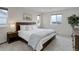 Bright bedroom with large bed, white linens, wood furniture, and ample natural light at 10906 Touchstone Loop, Parker, CO 80134