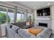 Inviting living room featuring a cozy gray sectional, fireplace and large windows for natural light at 10906 Touchstone Loop, Parker, CO 80134