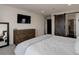 Serene main bedroom featuring a cozy bed, dresser, TV, and a sliding barn door to the walk-in closet at 10906 Touchstone Loop, Parker, CO 80134