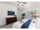 Bright bedroom featuring vaulted ceiling, ceiling fan, mounted television and large windows with plantation shutters at 9491 Southern Hills Cir, Lone Tree, CO 80124