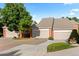 Exterior view of townhomes with attached garages, mature trees, and well-manicured landscaping at 9491 Southern Hills Cir, Lone Tree, CO 80124