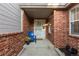 Charming front porch with brick accents and a cozy blue chair with flowers at 9491 Southern Hills Cir, Lone Tree, CO 80124