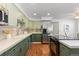 Spacious kitchen with green cabinets, stainless appliances and backsplash at 9491 Southern Hills Cir, Lone Tree, CO 80124