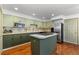 Open kitchen with stainless steel appliances, tile backsplash and green cabinets at 9491 Southern Hills Cir, Lone Tree, CO 80124