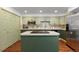Bright kitchen with stainless steel appliances, green cabinets, and tile backsplash at 9491 Southern Hills Cir, Lone Tree, CO 80124