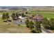 Aerial view showcasing the sprawling estate with lush landscaping, circular driveway, and stunning mountain views at 6330 Old Orchard Ln, Sedalia, CO 80135