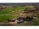Aerial view of an estate with a pond surrounded by rolling green fields and hills at 6330 Old Orchard Ln, Sedalia, CO 80135