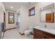 Bathroom with a modern sink, toilet, mirror, and a glass shower enclosure, complemented by natural light from a window at 6330 Old Orchard Ln, Sedalia, CO 80135