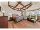 A cozy main bedroom features a beautiful wood-beamed ceiling and large windows at 6330 Old Orchard Ln, Sedalia, CO 80135