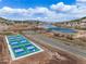 This aerial view showcases pickleball courts, a lake, a walking bridge and beautiful views at 16 Prairie St, Palmer Lake, CO 80133