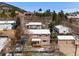 Aerial view showcasing a two-story home with a detached garage and snow-covered yard at 16 Prairie St, Palmer Lake, CO 80133