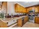 Well-lit kitchen featuring wooden cabinets, stainless steel appliances, and a countertop with bar seating at 16 Prairie St, Palmer Lake, CO 80133