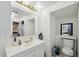 Bathroom with a white vanity, toilet, and a mirror, alongside convenient storage shelves at 21111 E 43Rd Ave, Denver, CO 80249