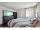 Comfortable bedroom featuring a dresser, TV, window, and a bed with a decorative quilt at 21111 E 43Rd Ave, Denver, CO 80249