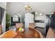Open-concept dining area with modern chandelier, hardwood floors, and connection to living room and kitchen at 21111 E 43Rd Ave, Denver, CO 80249