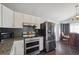 Bright kitchen with stainless steel appliances, granite countertops, tile backsplash and access to the dining area at 21111 E 43Rd Ave, Denver, CO 80249