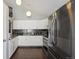 Well-lit kitchen features white cabinets, stainless steel appliances, vaulted ceilings, and modern pendant lighting at 21111 E 43Rd Ave, Denver, CO 80249