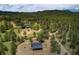 Expansive aerial view of the property showcasing the house, surrounding trees, and the mountainous landscape at 97 Soda Creek Rd, Evergreen, CO 80439