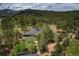 An aerial shot reveals a well-maintained estate with mature trees and fencing in a picturesque wooded setting at 97 Soda Creek Rd, Evergreen, CO 80439