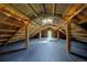 Unique attic space with exposed beams, skylight, and wooden flooring, ideal for storage at 97 Soda Creek Rd, Evergreen, CO 80439