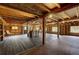Rustic basement features wooden beams, hardwood floors, and exposed structure at 97 Soda Creek Rd, Evergreen, CO 80439