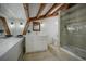 Bathroom showcases exposed beams, stone flooring, a glass shower, and modern fixtures, providing a luxurious and rustic retreat at 97 Soda Creek Rd, Evergreen, CO 80439