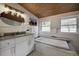 Bright bathroom with a soaking tub, granite counters, modern fixtures, and views from the windows, creating a spa-like experience at 97 Soda Creek Rd, Evergreen, CO 80439