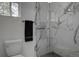 Contemporary bathroom with marble tiled shower, toilet, and sleek glass enclosure at 97 Soda Creek Rd, Evergreen, CO 80439