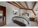Cozy bedroom with exposed beams, a rustic wood bed frame, and natural light, creating a warm and inviting atmosphere at 97 Soda Creek Rd, Evergreen, CO 80439