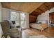 Comfortable bedroom features hardwood floors, a cozy seating area, and natural light, creating a relaxing and inviting space at 97 Soda Creek Rd, Evergreen, CO 80439