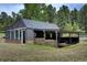 Modern gray home with stone accents, a covered porch, and a well-manicured lawn at 97 Soda Creek Rd, Evergreen, CO 80439