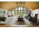 Inviting living room boasts vaulted wood ceilings, a large picture window, and comfortable seating, perfect for relaxing or entertaining at 97 Soda Creek Rd, Evergreen, CO 80439