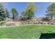 Expansive backyard featuring lush green grass, landscaping, and recreational space at 12825 W 81St Ave, Arvada, CO 80005